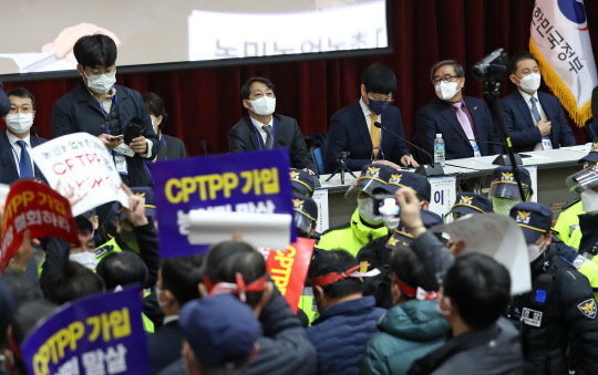 25일 오전 정부세종청사 12동 대강당에서 포괄적·점진적 환태평양경제동반자협정(CPTPP) 공청회가 열린 가운데 일부 방청객이 공청회 철회를 요구하며 경찰과 대치하고 있다. <연합뉴스>